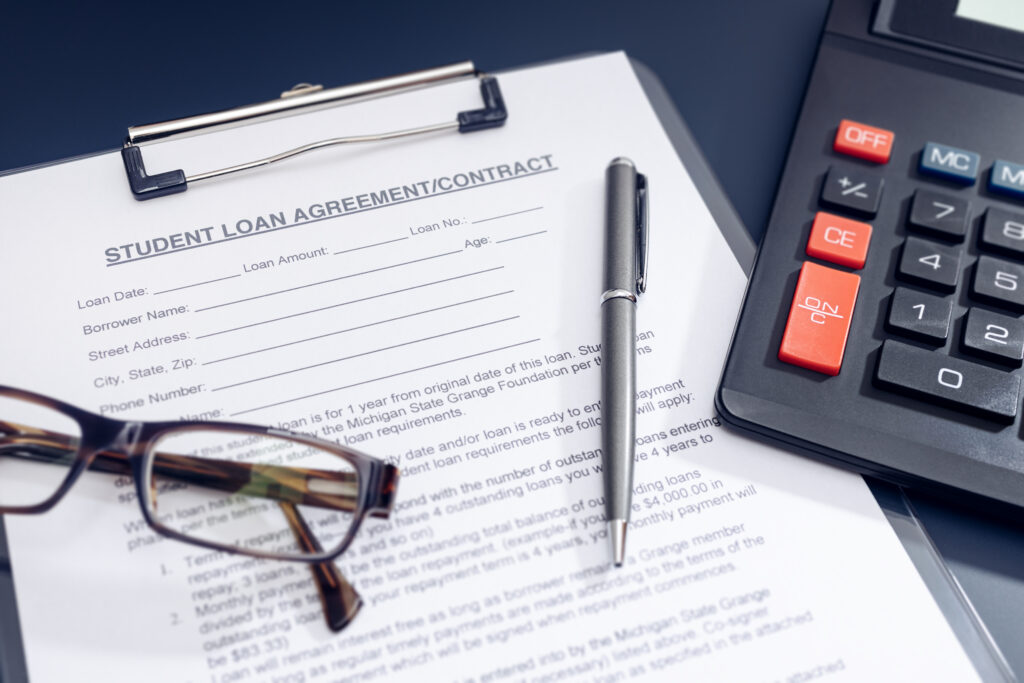 Blank Student Loan Application, calculator, pen and eyeglasses on table. 