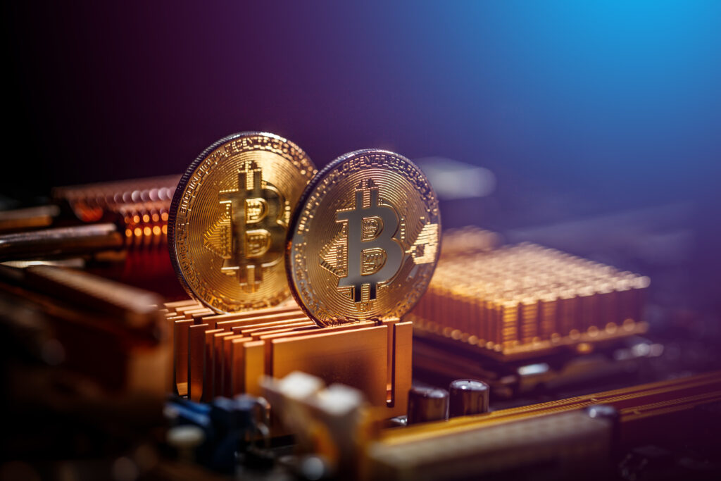 Two gold bitcoins sitting on top of computer processors.