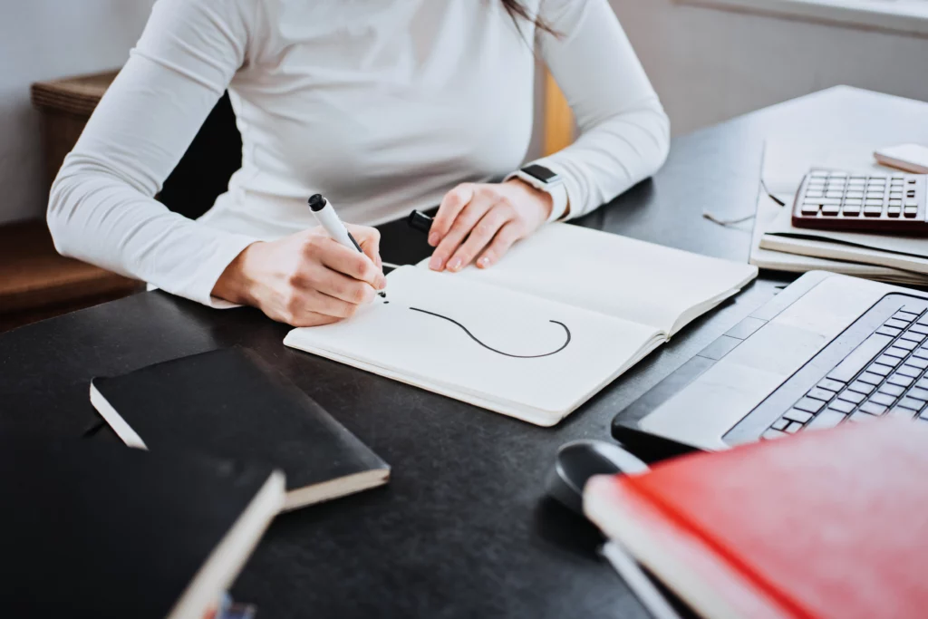 A woman has drawn a large question mark on a piece of paper