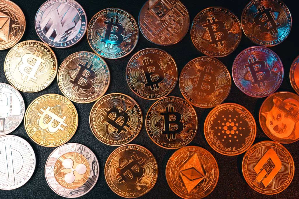 crypto coins with various logos are laid out across a black surface