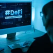 A woman at a computer with the text "#DeFi" written on the screen.