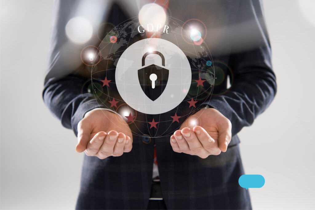 A man in a business suit is standing with his hands outstretched, facing up. Above his palms is a silver padlock logo, representing digital security.