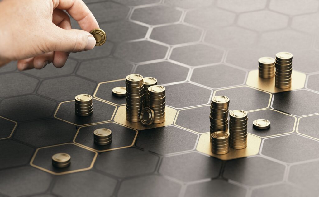 A hand is putting down piles of gold coins on a black and gold hive image surface. The images represents managing assets on the blockchain.